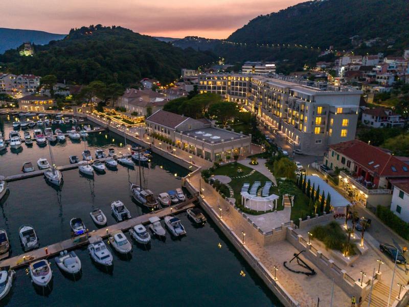 Vue nocturne d'une marina avec hôtel et promenade éclairée dans une ville côtière