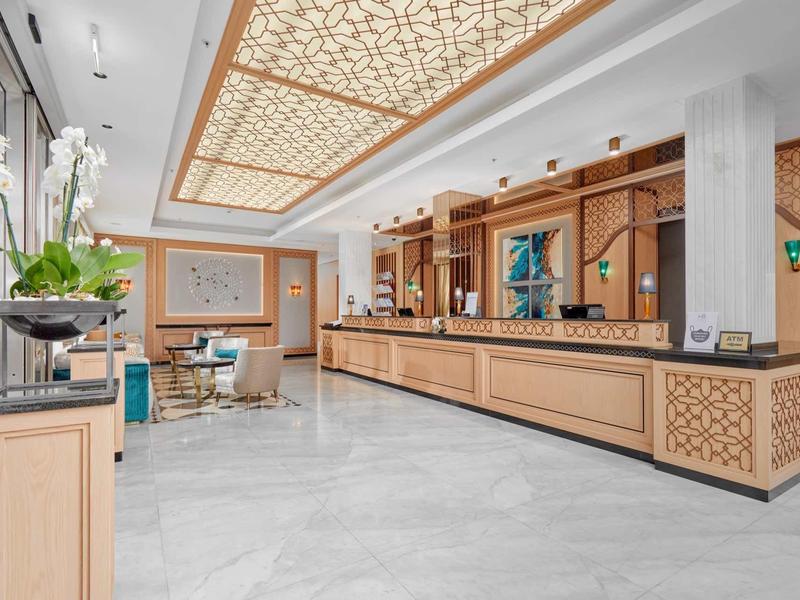 Innenansicht einer modernen Rezeption mit hellem Marmorfußboden und dekorativer Holzverkleidung.