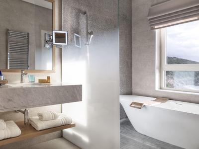 Modernes Badezimmer mit freistehender Badewanne, Glas-Duschwand und großem Fenster mit Bergblick.