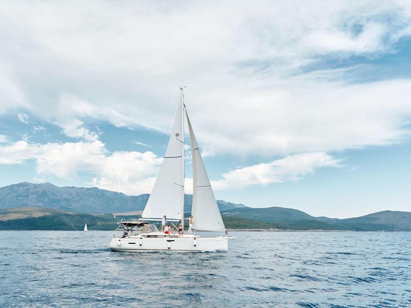 Moderne badkamer met vrijstaand ligbad, raamzicht en wastafel met handdoeken eronder.