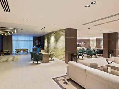 Nowoczesne lobby hotelowe z miejscami do siedzenia, lampami stołowymi i światłem pośrednim.