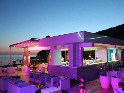 Nowoczesny bar na plaży z oświetleniem lounge i miejscami do siedzenia o zachodzie słońca.