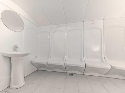 Weißer Duschraum mit mehreren Duschen nebeneinander und einem weißen Waschbecken links.