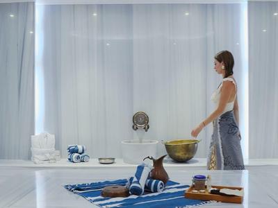 Moderní místnost s velkými okny a uvolněnou atmosférou, žena stojí vedle koberce.