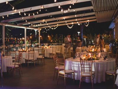 Beleuchtete Terrasse mit gedeckten Tischen und Stühlen bei Nacht