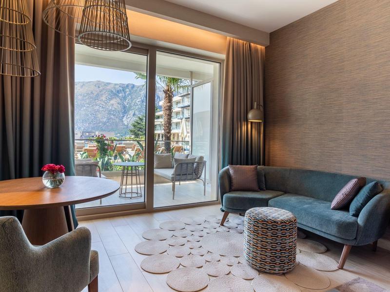 Moderně zařízený hotelový pokoj s balkonem a výhledem na hory