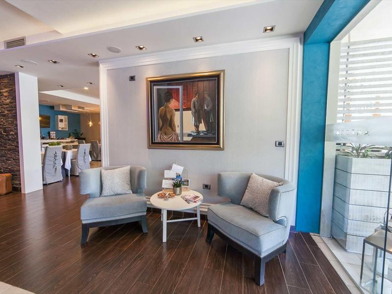 Área de descanso acogedora con dos sillones, mesa y pintura en la pared en un hotel.