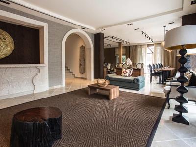 Jasny, nowoczesny salon z dużym dywanem, kominkiem i stylowymi meblami.