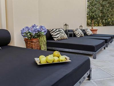 Czarne leżaki z poduszkami i talerzem owoców w cichym salonie na zewnątrz