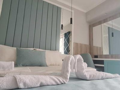 Hell eingerichtetes Hotelzimmer mit einem großzügigen Bett und Handtüchern in Schwanform.