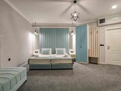 Modernes Hotelzimmer mit Doppelbett, blauen Akzenten und grauem Teppichboden