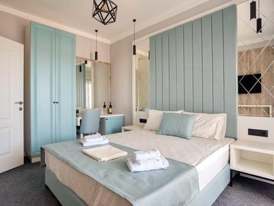 Camera da letto moderna con armadi azzurri, letto matrimoniale e design pulito e minimalista.