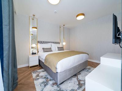 Nowoczesny pokój hotelowy z podwójnym łóżkiem i eleganckim dywanem.