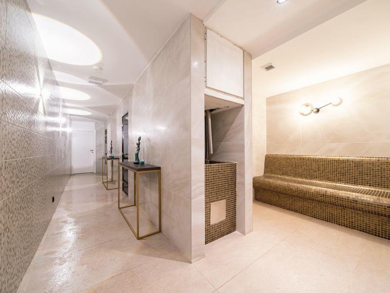 Moderner Spa-Bereich mit Mosaik-Dampfraum und langem braunem Saunabank aus Mosaikfliesen.