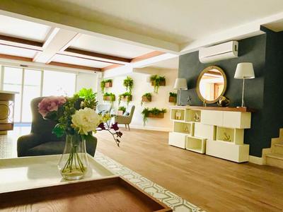 Gemütlicher Hotel- oder Aufenthaltsraum mit Holzboden und Pflanzenwand.