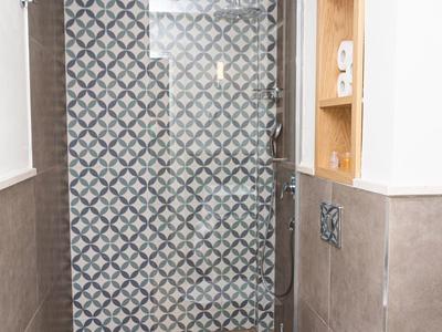 Moderner Badbereich mit gemusterter Glaswand, Wand-WC und offenen Holzregalen.