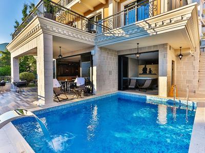 Moderne buitenruimte met zwembad, terras en zithoek van een hotel in zonlicht.