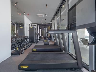 Palestra moderna con tapis roulant, pesi e grandi finestre con vista all'esterno