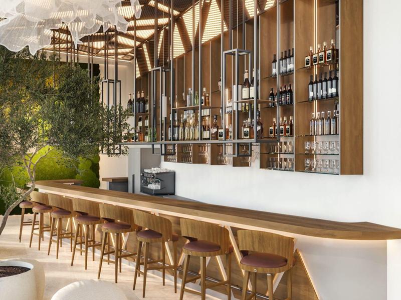 Moderner Gastraum mit langen Holztischen, Stühlen und großen Fensterfronten, helle Sitzmöbel.