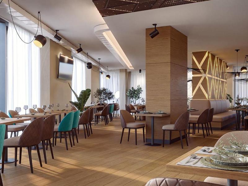 Moderner Gastraum mit Holzboden, großen Fenstern, grünen und braunen Stühlen und gedeckten Tischen.