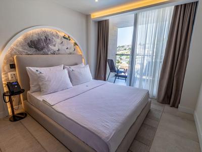 Nowoczesny pokój hotelowy z łóżkiem podwójnym, balkonem i widokiem na miasto