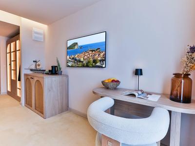 Moderner Wohnraum mit weißem Sessel, hellem Holztisch, Dekoration und Wandbild in neutralen Tönen.