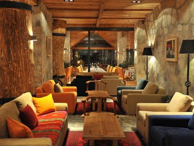 Gemütlicher Lounge-Bereich mit Sofas und Holztischen in einem rustikalen Hotelambiente.