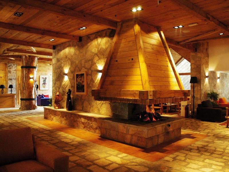 Gezellig hotel loungegedeelte met een open haard en rustieke houten inrichting.