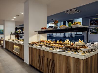 Große Auswahl an Gebäck und Desserts in einem modernen Buffetbereich eines Hotels.