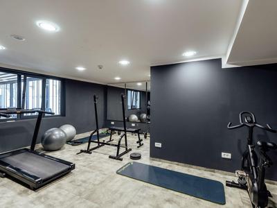 Palestra moderna con tapis roulant, palle da ginnastica, pesi e attrezzature per l'allenamento.