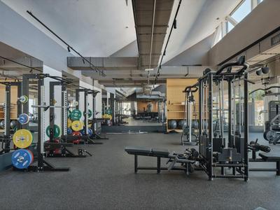 Grote moderne sportschool met apparatuur en gewichten in een hotel.
