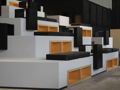 Moderne, minimalistische Sitzstufen mit schwarzen Polstern und Holzdetails in einem Innenraum.