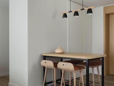 Moderner Essbereich mit hohem Tisch und zwei Holzstühlen auf Holzboden.