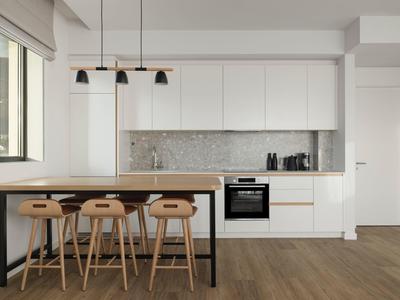 Moderne weiße Küche mit Bartresen und Holzstühlen in einem hellen Raum.