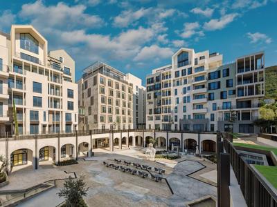 Modern hotelcomplex met binnenplaats, ligstoelen en lichte lucht