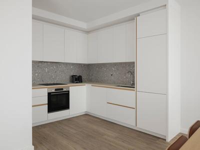 Moderne weiße Küche mit Holzarbeitsplatte, grauem Fliesenspiegel und Holzboden.