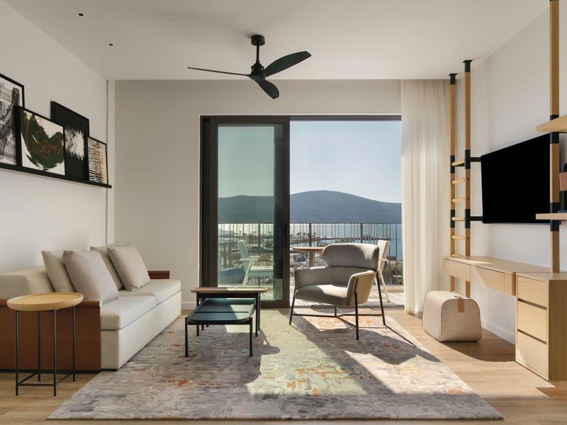 Moderner Speiseraum mit verschiedenen Stühlen und großen Fenstern in einem Hotel.