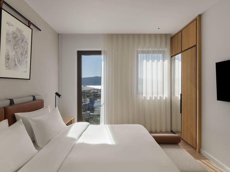 Moderner Hotelbarbereich mit runden orangen Barhockern und indirekter Beleuchtung.