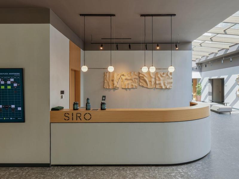 Moderner Hotellobby-Empfang mit hellen Holzakzenten und stilvoller Beleuchtung.