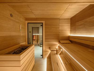 Sauna moderne avec murs en bois, bancs et éclairage apaisant.