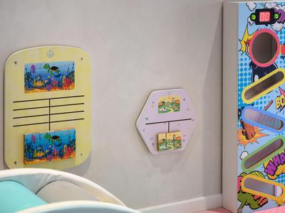 Décoration murale avec cartes postales colorées à côté d'une machine à flipper rétro dans une chambre d'hôtel.