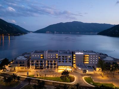 Hôtel moderne avec chambres éclairées sur une côte calme au crépuscule.