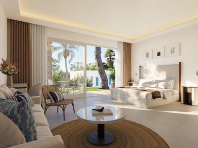 Heller Hotelzimmer mit gemütlichem Doppelbett, Sofa, Stühlen und Blick auf grünen Garten.