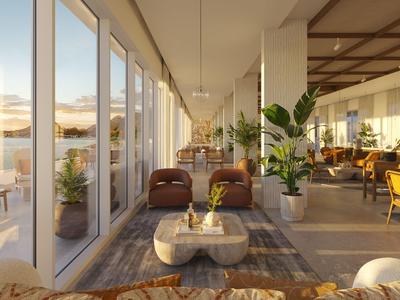 Salon moderne et lumineux avec fenêtres panoramiques et vue sur un lac au coucher du soleil.