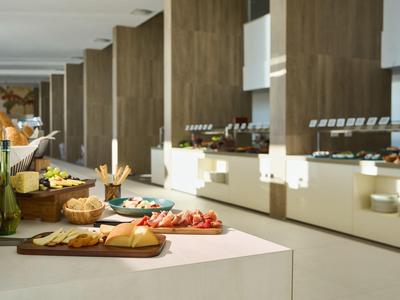 Bufet z świeżymi owocami, pieczywem i wędlinami w nowoczesnej restauracji hotelowej.