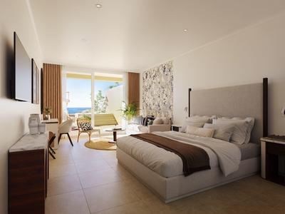 Modernes Hotelzimmer mit großem Bett, Sitzbereich und Balkon mit Meerblick.