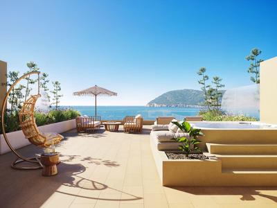 Terrasse mit Hängestuhl, Sofa und Meerblick bei klarem Himmel