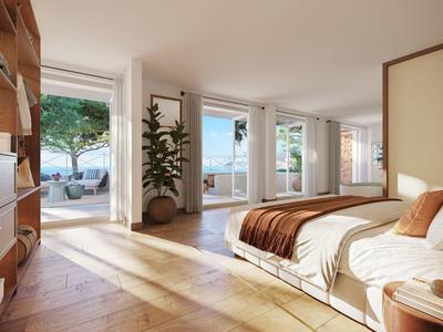 Helles Hotelzimmer mit Doppelbett, Holzmöbeln und Zugang zu einer Terrasse mit Blick aufs Meer.