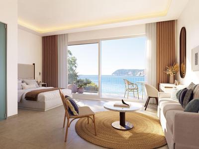 Modernes Hotelzimmer mit großen Fenstern und Meeresblick, hellem Interieur und gemütlicher Einrichtung.