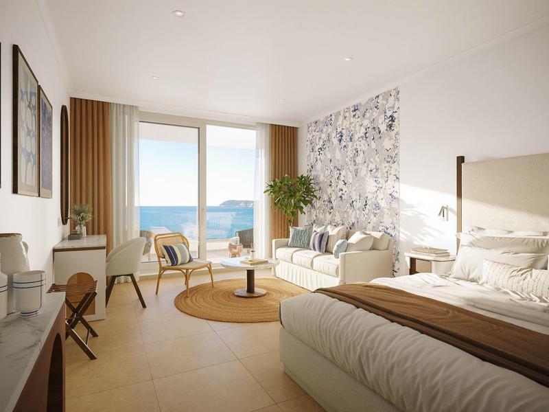 Helles Hotelzimmer mit Meerblick, Doppelbett, Sofa, Stühlen und modernem Dekor.